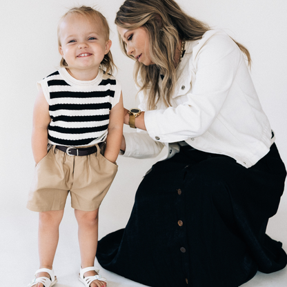Woman and child standing close together on a white background