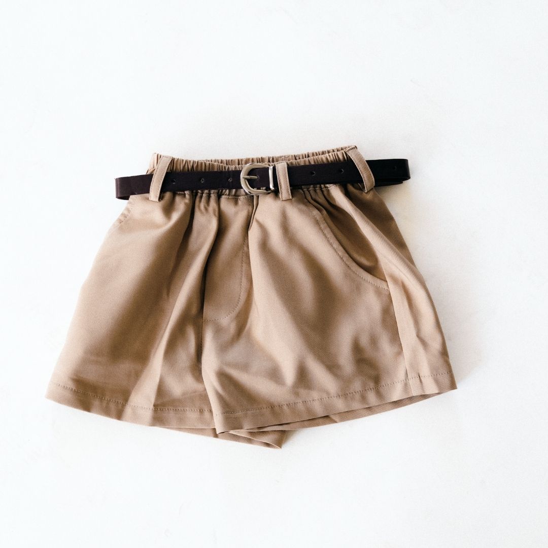 Beige shorts with a black belt on a white background